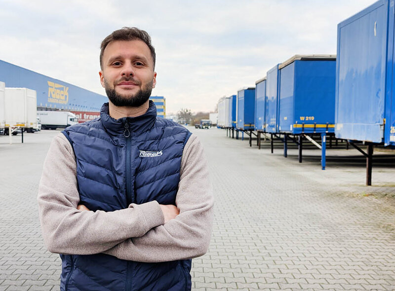 Manuel Yakoub steht mit verschränkten Armen auf dem Hof der Rieck Logistik-Gruppe