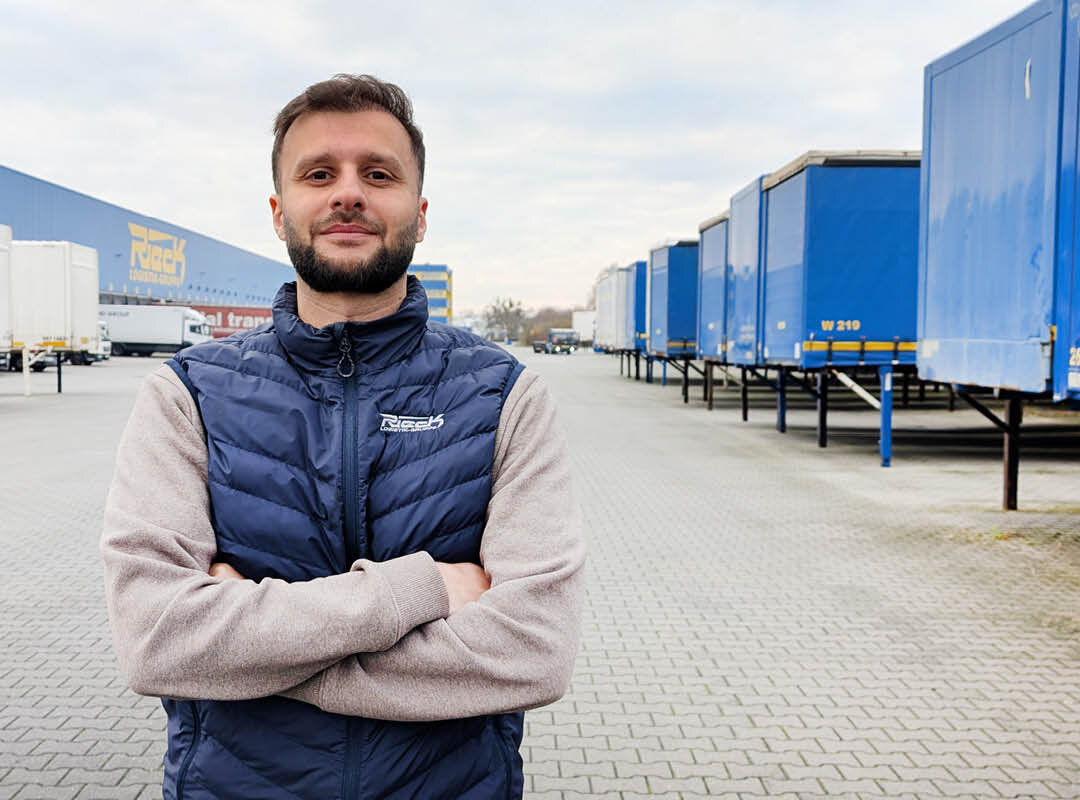 Manuel Yakoub steht mit verschränkten Armen auf dem Hof der Rieck Logistik-Gruppe