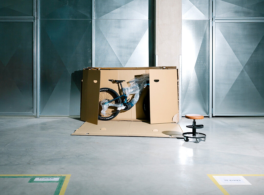 In einer Halle ist ein halboffener Karton mit einem Fahrrad drin
