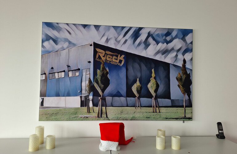Foto: Bild hängt an einer Wand über einem Sideboard, Bildmotiv: Logistikhalle der Rieck Logistik-Gruppe als Aquarell gezeichnet 